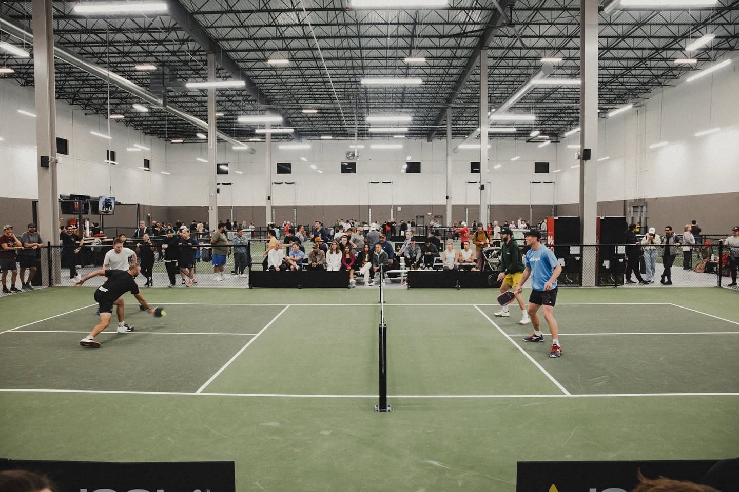 Pickleball players mid-rally on court